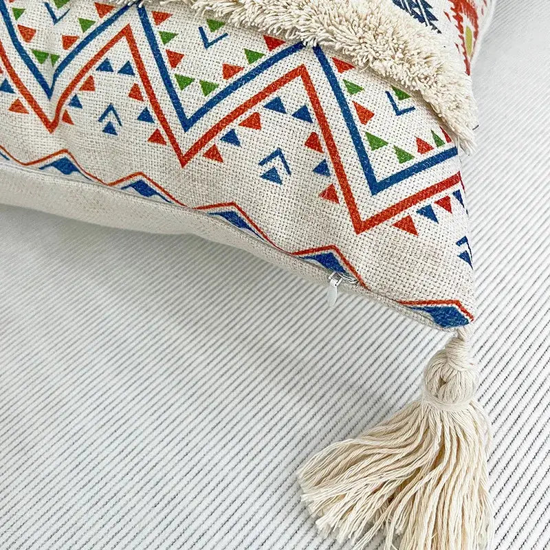 Cream-colored decorbites geometric bohemian pillow case with red blue green triangles and mustard yellow tassel decor