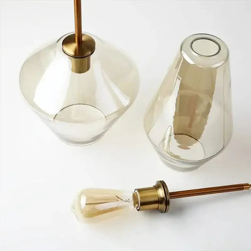 A sleek amber-tinted glass chandelier lighting with brass-finished stem and base pendant light for kitchen use