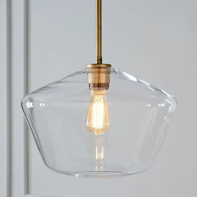 Clear glass pendant light with brass-finished metal rod and exposed edison bulb in geometric glass pendant lights set