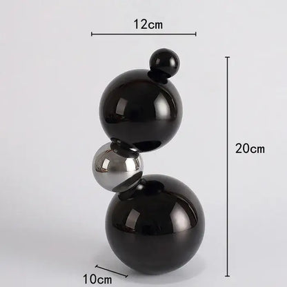 A sleek geometric butterfly crystal ball home decor featuring three stacked glossy black and silver spheres