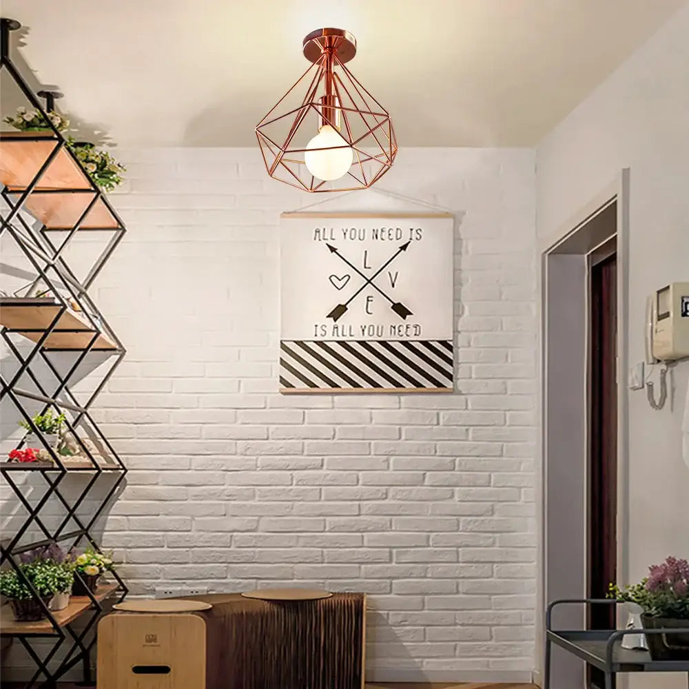 Copper-colored geometric cage iron ceiling light fixture with wireframe design and exposed bulb for dining room