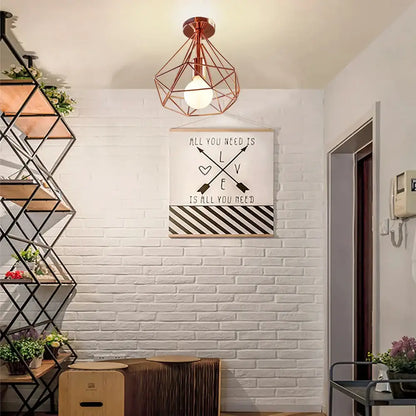 Copper-colored geometric cage iron ceiling light fixture with wireframe design and exposed bulb for dining room