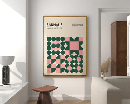 A framed decorbites bauhaus geometric canvas print with green and pink design in a light wood frame for home decor