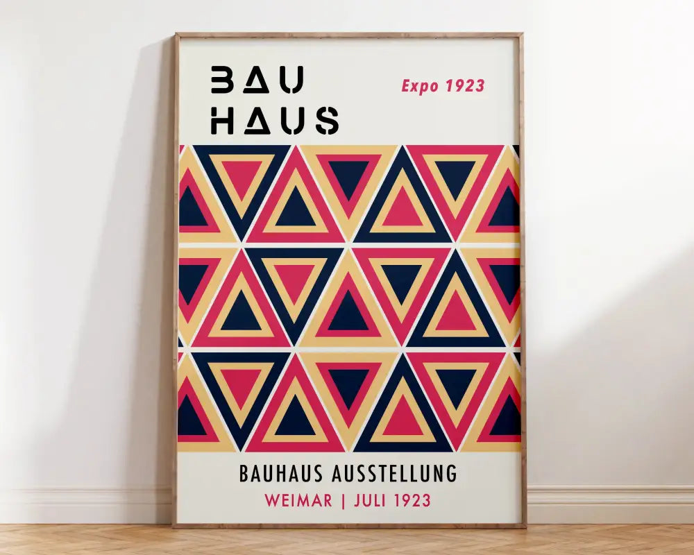 A framed decorbites bauhaus geometric canvas print featuring overlapping navy blue coral pink and beige triangles for home decor
