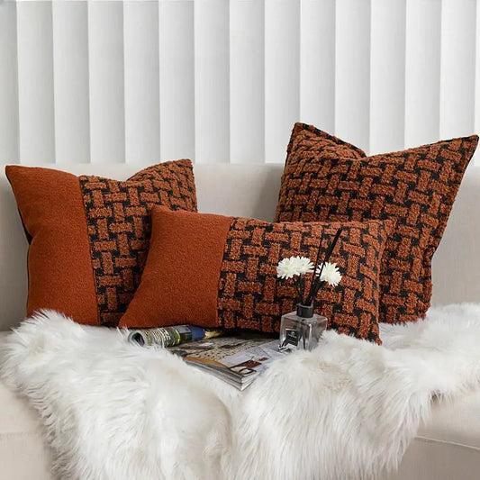 Three rectangular throw pillows with textured caramel color velvet cushion cover in burnt orange and dark brown tones on sofa