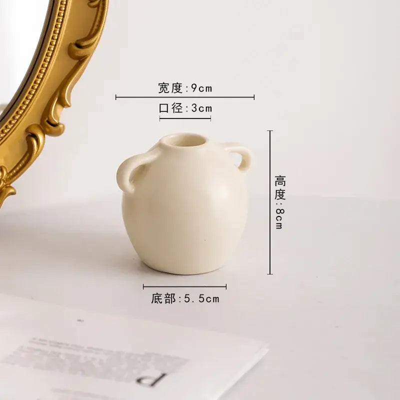 Cream-colored ceramic candle holder with two small handles and rounded body from decorbites geometric ceramic set