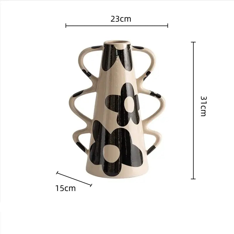 Cream-colored ceramic vase with black floral decals and multiple curved handles complements geometric check pattern decor