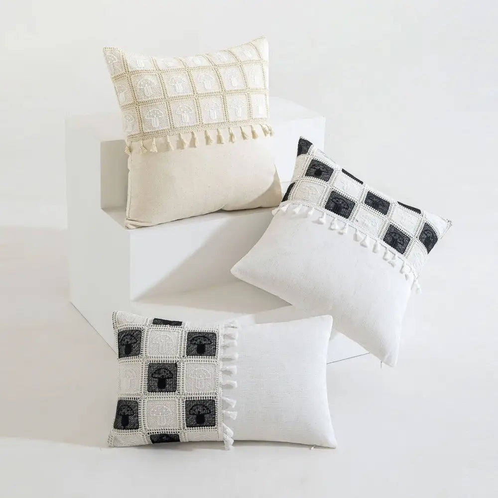 Cream-colored geometric checker cushion cover with black and white embroidered arches and tassel trim for living room decorbites decor