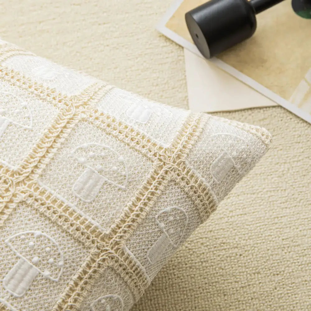 Cream-colored cushion cover with delicate crochet mushroom motifs and textured woven fabric for geometric checker decorbites