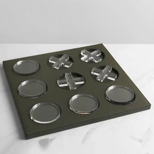 Dark green leather tray with nine circular and cross-shaped acrylic coasters in geometric checkerboard home decor style