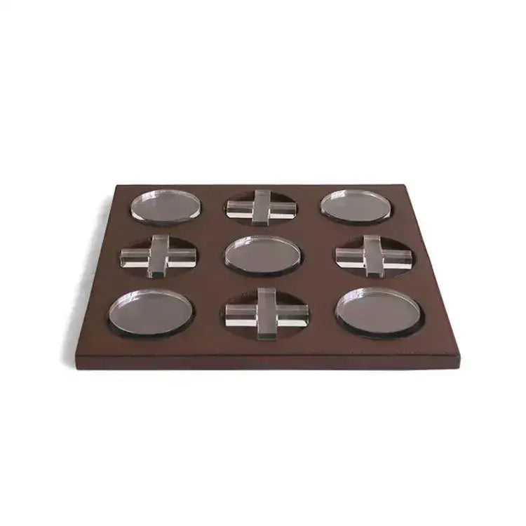 Brown wooden tray with nine recessed slots holding silver metallic oval coasters and cross pieces for geometric checkerboard home decor