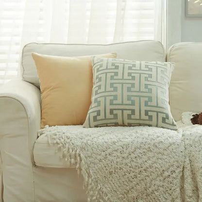 A square decorbites geometric chenille throw pillowcase in beige and light blue with a gray maze pattern on a cream couch