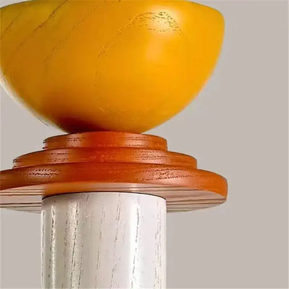 A vibrant yellow hand-carved wooden bowl on warm-toned wood rings mounted on white-washed post for led wooden pendant light decorbites