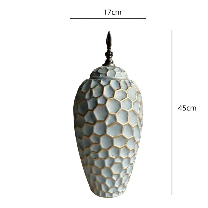 A 45cm tall ceramic vase with geometric diamond check honeycomb texture in muted gray and gold tones with metallic lid