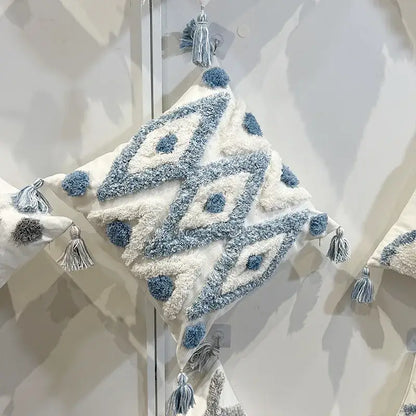 Cream-colored geometric diamond tufted embroidery pillow with soft blue and white yarns and tassels for living room decor