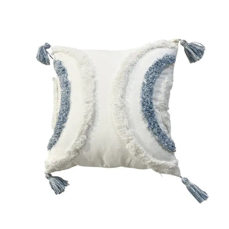 Cream-colored geometric diamond tufted pillow with blue and white textured fringe and tassels for living room decor