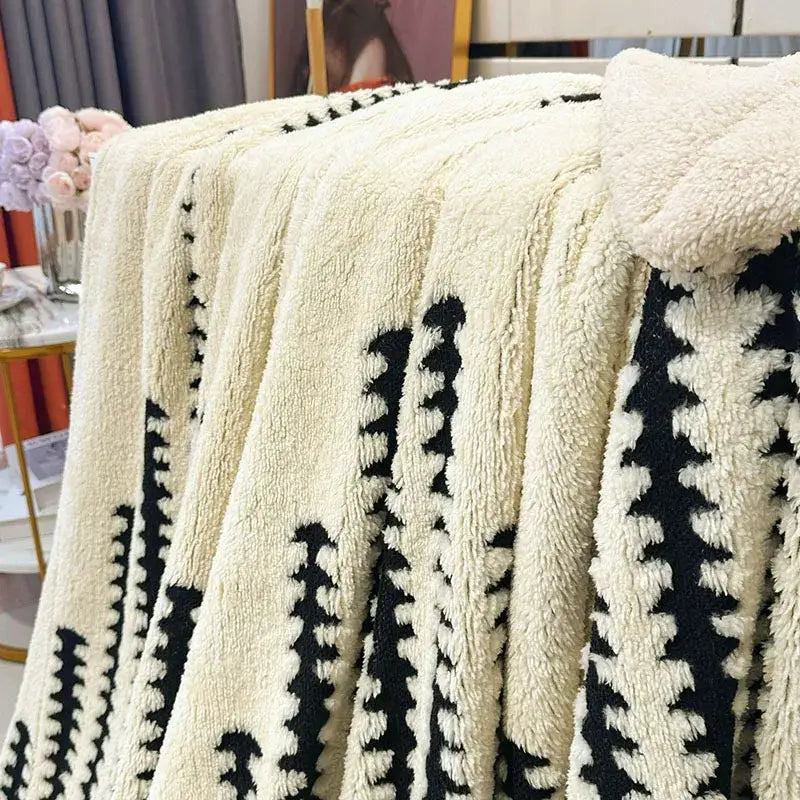 Cream-colored plush double layer lamb fleece blanket with black geometric patterns for bedroom throw use