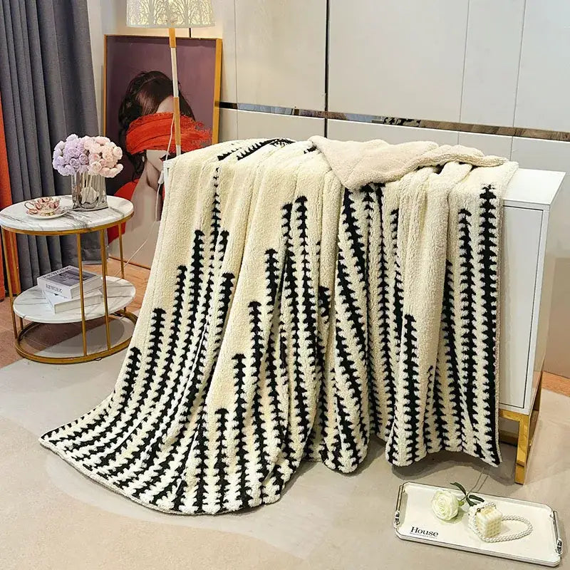 Cream-colored plush throw blanket with bold black stripes featuring a soft textured double layer lamb fleece design
