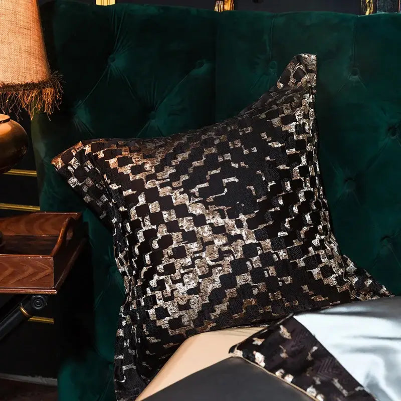 Black and silver geometric-patterned velvet throw pillow complementing embroidered egyptian cotton bedding set
