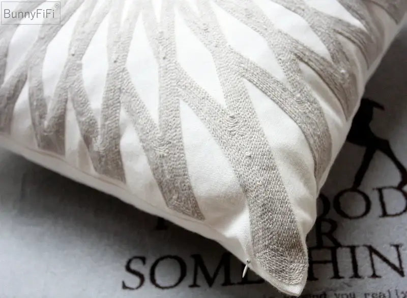 A cream cushion cover with a textured grayish beige geometric embroidered pattern for living room decor by decorbites geometric embroidered