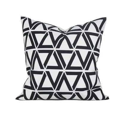 A square throw pillow cushion cover with bold black and white interlocking triangles in geometric embroidered noble design