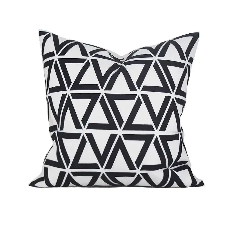 A square throw pillow cushion cover with bold black and white interlocking triangles in geometric embroidered noble design