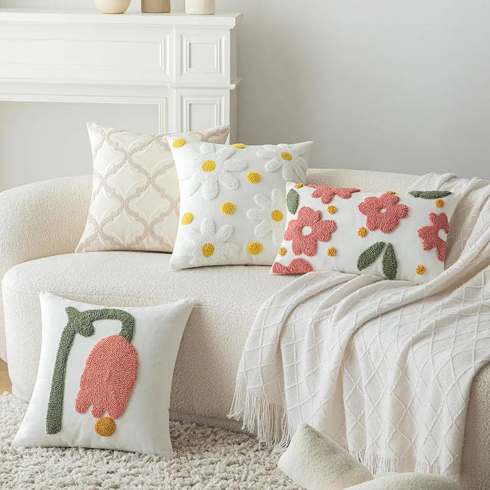 White throw pillows with textured embroidered floral designs in pink yellow and green featuring decorbites geometric embroidery cushion cover