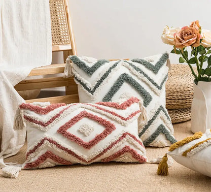 Cream-colored cushion cover with dusty rose and sage green geometric embroidery boho patterns and soft tassels decorbites