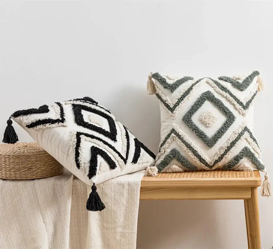 Two textured throw pillows with decorbites geometric embroidery cushion covers in black white and gray cream with tassels