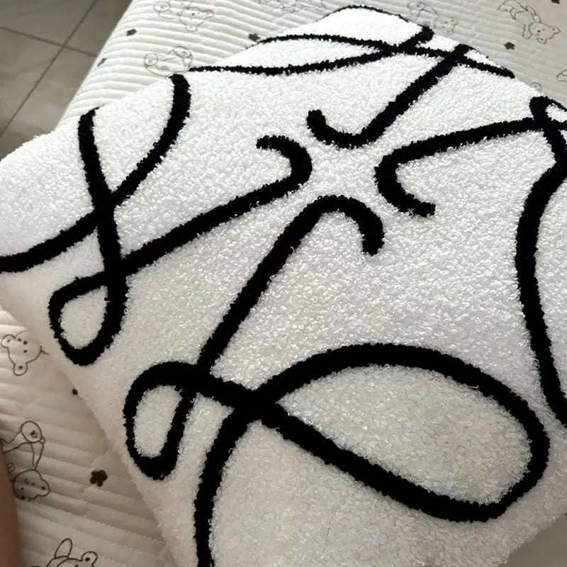 White plush towel with bold black abstract line design showcasing decorbites geometric embroidery cushion covers