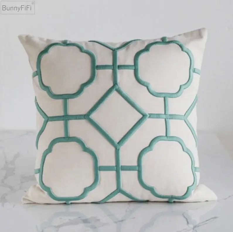 Cream-colored cushion cover with teal decorbites geometric embroidery for yellow and teal living room decor