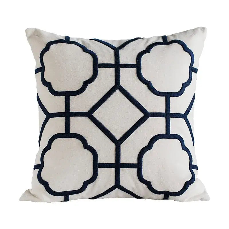 Cream-colored cushion cover with navy blue decorbites geometric embroidery featuring cloud shapes and diamond motifs