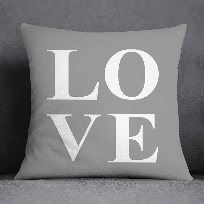 Gray throw pillow case with bold white love lettering featuring decorbites geometric floral print for living room decor