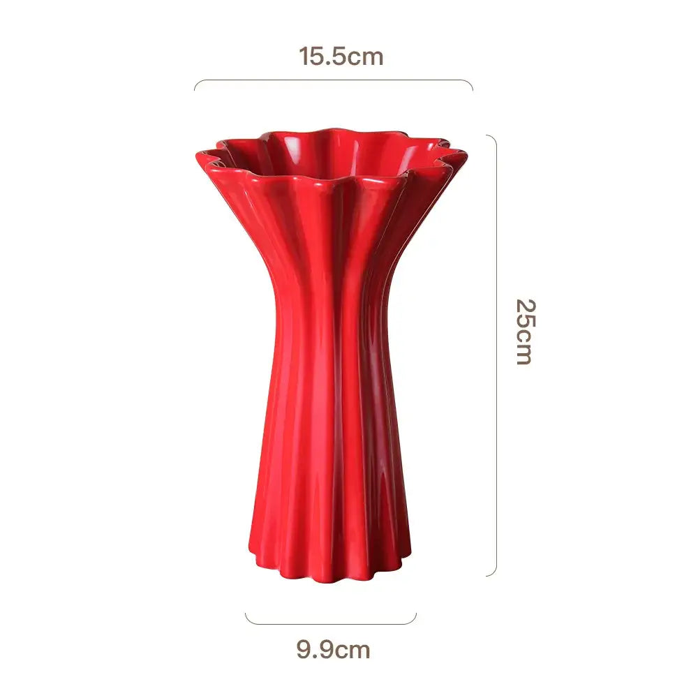 Vibrant red ceramic vase with geometric fold pattern and fluted petal-like rim and base for living room decor with twine