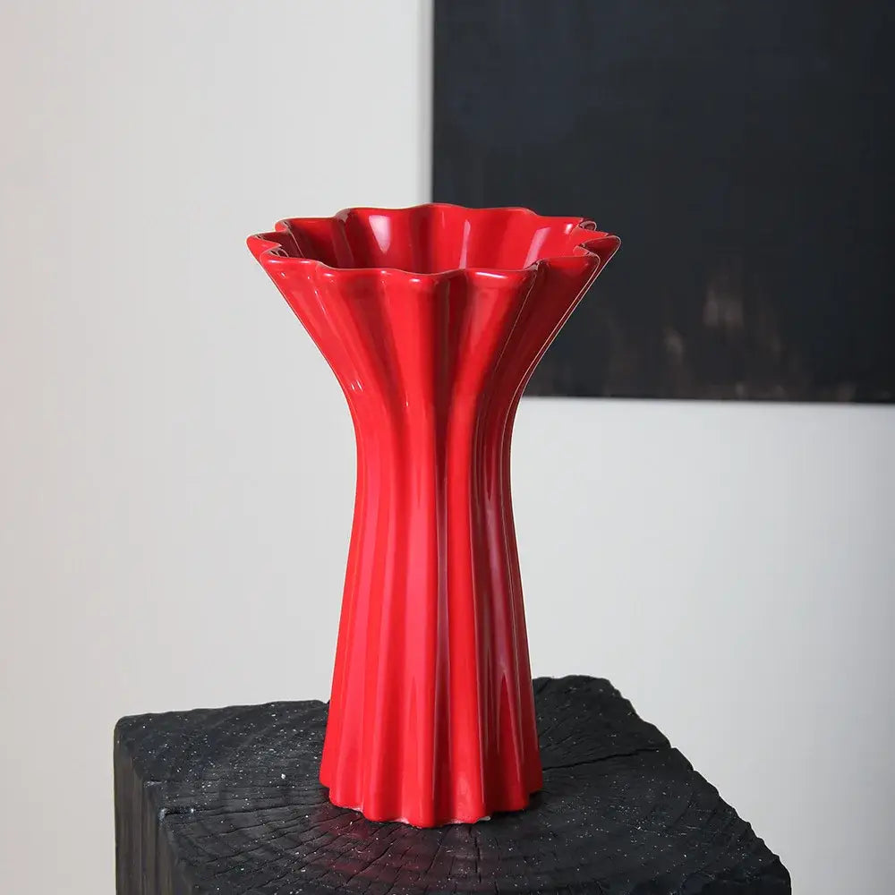 Vibrant red ceramic vase with geometric fold pattern and fluted petal-like rim for living room decor with twine