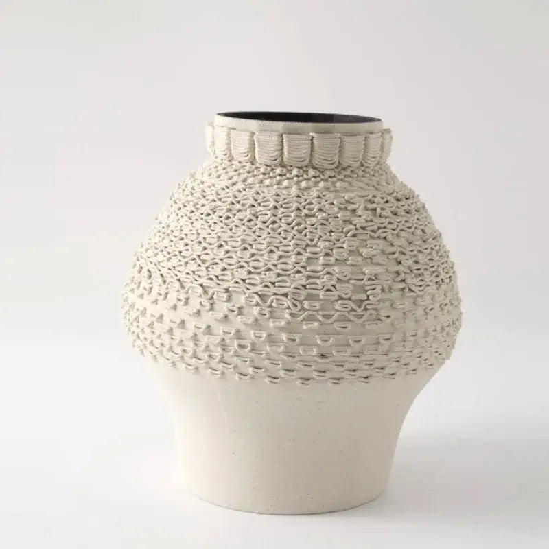 Cream-colored geometric folding ceramic vase with textured woven patterns and black interior rim for living room decor
