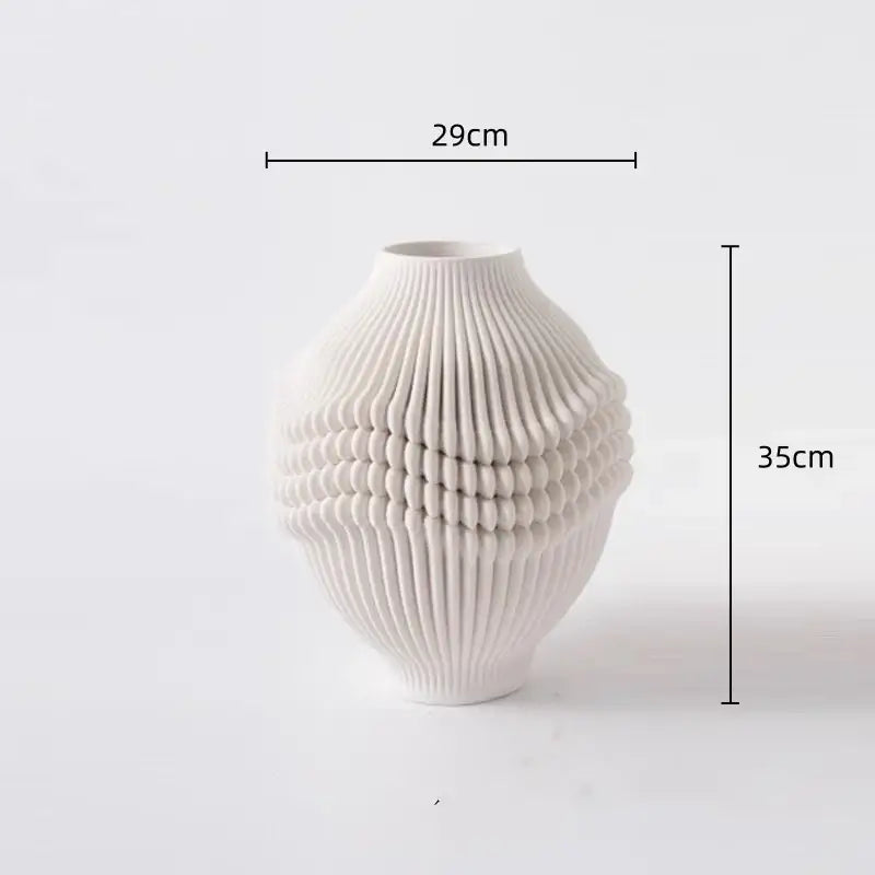 A white ceramic vase with a textured ribbed surface and oval shape for geometric folding ceramic decorbites decor