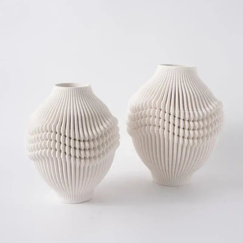 Two off-white geometric folding ceramic vases with intricate ribbed textures for living room decor by decorbites