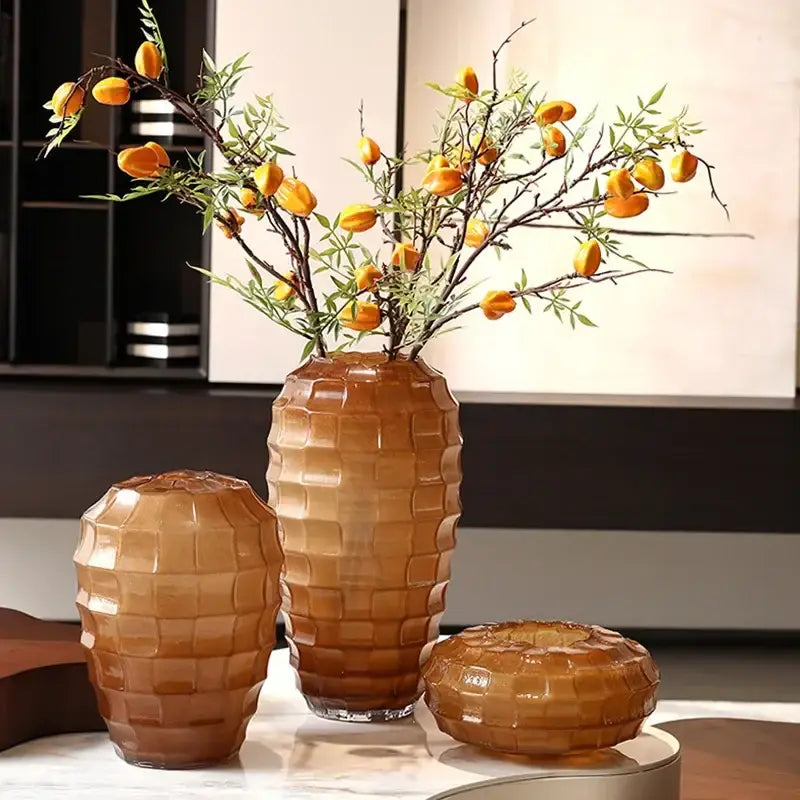 Set of three amber-toned geometric frosted glass vases with a textured pattern for living room decor by decorbites