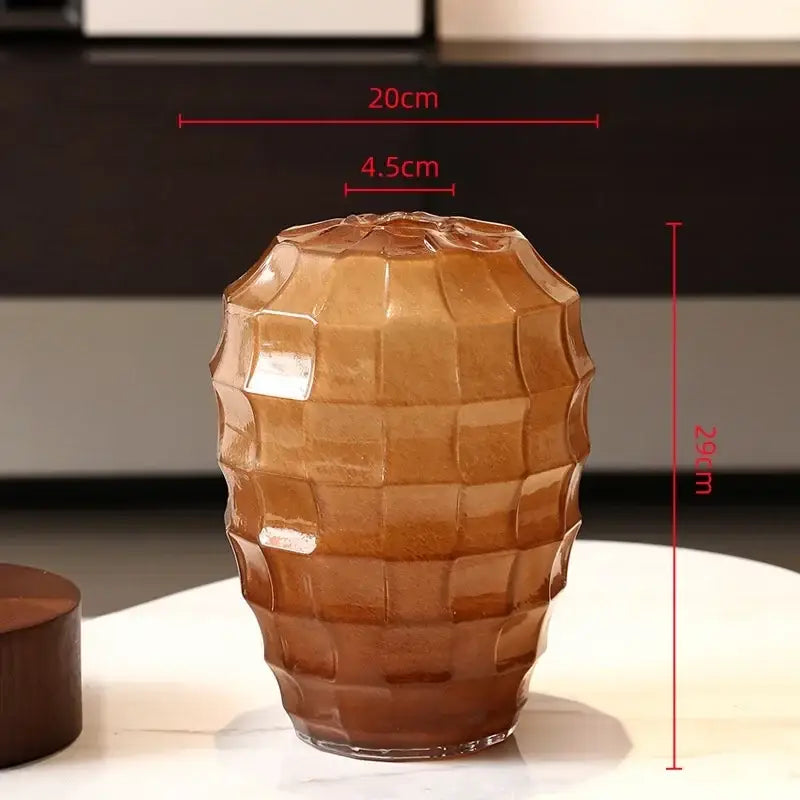 A translucent amber glass vase with a geometric frosted glass faceted design and rounded base for living room decor
