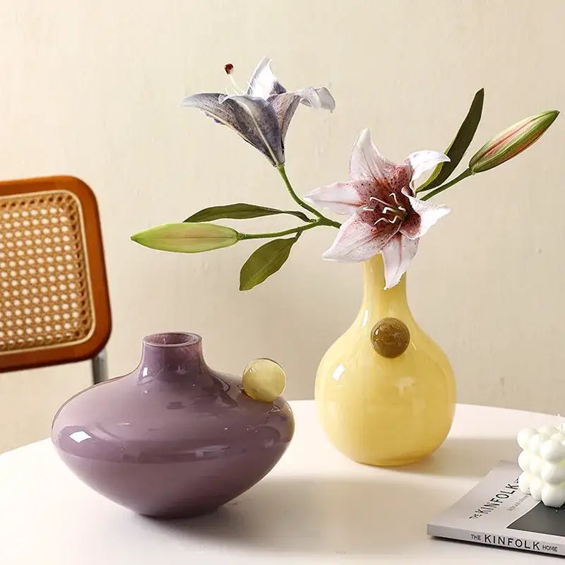 A glossy yellow ceramic vase with a rounded body and geometric glass sphere accent for living room decorbites decor