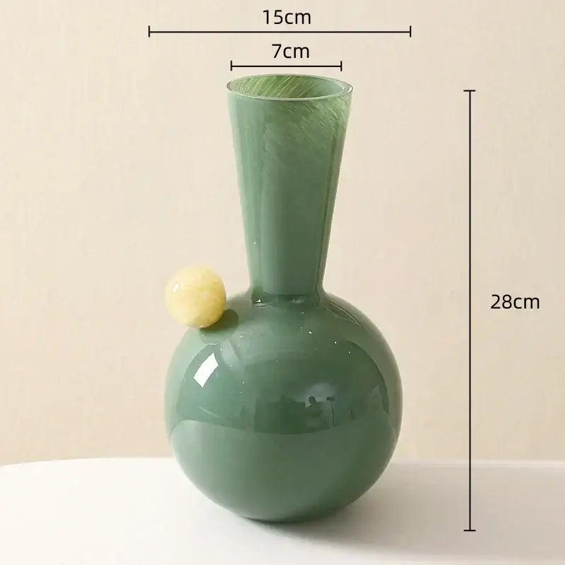 A sleek matte sage green glass sphere vase with a pale yellow accent, perfect for decorbites geometric glass living room decor