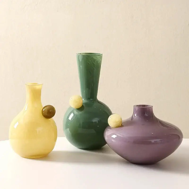 Three colorful glossy glass sphere vases with rounded bodies and slender necks for decorbites geometric glass decor