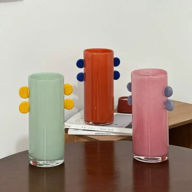Three colorful decorbites geometric glass vases with rounded color patches and button-like handles for living room decor
