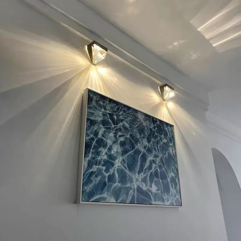 A framed artwork with textured blue water surface in a white frame paired with a geometric gold crystal led wall sconce bedroom light decorbites crystal led