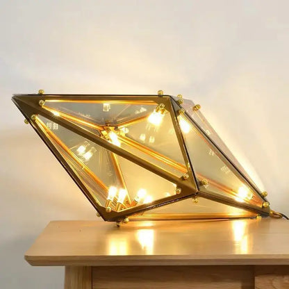 Geometric gold brass-framed led pendant lights with clear glass panels and warm interior lighting for dining room