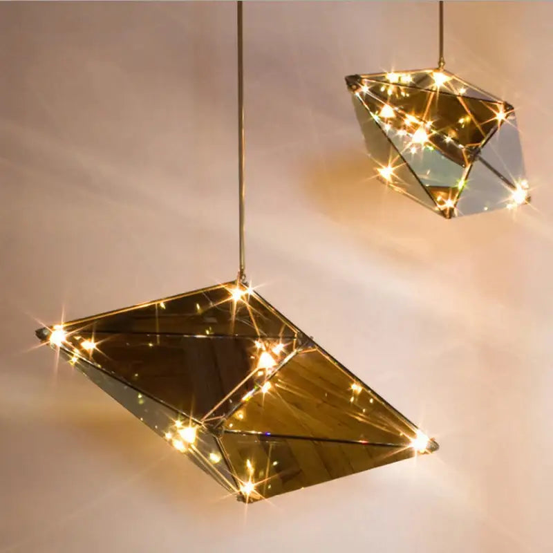 Gold geometric pendant lights with mirrored facets and warm led bulbs ideal for dining room led pendant lights