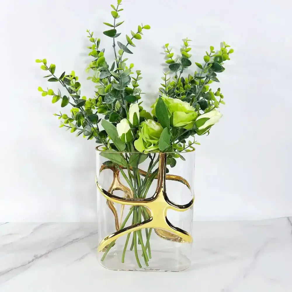 Clear glass vase with elegant gold-edged abstract curves holding eucalyptus and light green roses, decorbites gold-edged glass vase