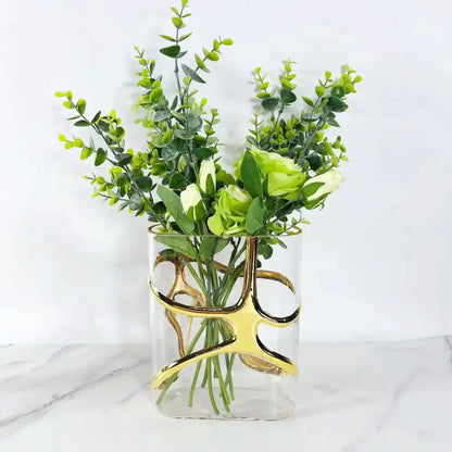 Clear glass vase with elegant gold-edged abstract curves holding eucalyptus and light green roses, decorbites gold-edged glass vase