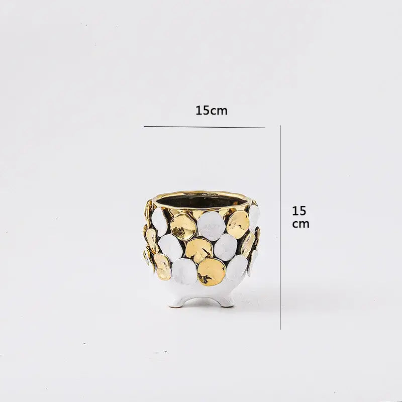 A white ceramic geometric gold leaf relief planter with textured surface and three small feet for living room decor